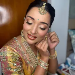 Less is pure elegance. This candid moment captures the soft glow and refined details of her makeup, with warm tones on the eyes and a natural, glossy lip.