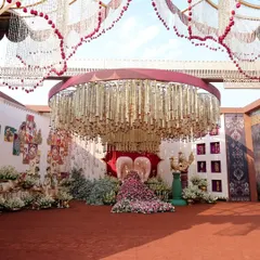 A breathtaking view of a custom-designed seating area. The centerpiece, a pair of hands holding a cascade of flowers, and the ceiling of floral strings create a truly unique and artistic environment for guests.