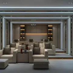 A luxurious home theater design with tiered seating for an authentic cinema experience. The room features plush armchairs, sophisticated wall paneling, and professional-grade lighting.