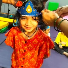 Getting ready for the Janmashtami celebration. This little girl is all smiles as we help her put on her Krishna crown, ready to join in the festive fun.