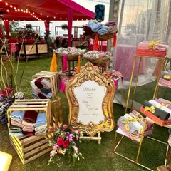 For a chilly evening event, we set up this thoughtful favor station with warm blankets. The elegant sign and organized display in crates and on stands make it both a practical and stylish addition to the decor.