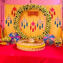 A traditional and vibrant Haldi ceremony stage. This setup features a bright yellow backdrop, a full arch made of fresh genda phool (marigolds), and decorative hangings to create the perfect festive atmosphere for pre-wedding functions.