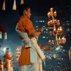 A close up of a priest during the Banganga Aarti, his focus intense as he holds the multi-layered diya. This shot captures the spiritual energy of the ceremony.
