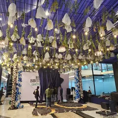 Another angle of the grand birthday setup, showing the scale of the ceiling decor and the balloon columns that frame the main stage area.