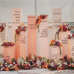 A straight-on shot of the 'Promise Pillars', showcasing the heartfelt and funny messages that tell the couple's story.