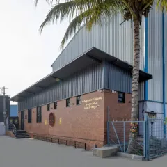 A side view of the facility, showing how the modern PEB structure sits atop the more traditional brick-clad ground floor.