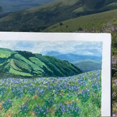The finished painting held up against the real-life landscape that inspired it. Capturing the essence of the Neelakurinji bloom was a surreal experience.