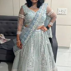 A full-length view of the powder blue lehenga with intricate white chikankari style embroidery. It's paired with a simple diamond necklace set, also for rent.