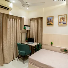 This bedroom features a compact study corner cleverly integrated next to the bed. The design includes a sleek desk, an ergonomic chair, and overhead storage, creating a functional workspace without cluttering the room.