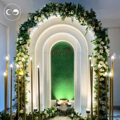A closer look at the contemporary arch setup, showcasing the clean lines and the beautiful contrast between the green panel and the white floral decor. This design is perfect for modern couples seeking elegance in a compact space.