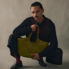 A model holding our handwoven tote in a unique olive green. The texture of the woven leather is soft yet durable, a quiet kind of luxury that is meant to be felt, not just seen.