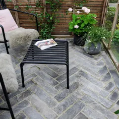 The choice of paving pattern can define an outdoor room. For this patio, we laid grey stone pavers in a classic herringbone pattern, adding a layer of texture and timeless design sophistication to the seating area.
