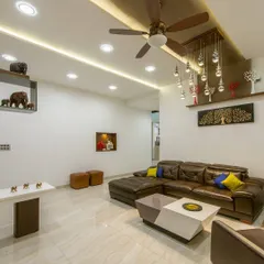 This living room showcases our approach to creating harmony through varied textures and curated decor. The plush leather sofa is balanced by modern art pieces and a unique cascading light fixture, resulting in a space that is both luxurious and comfortable.