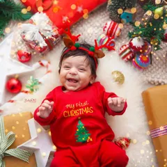 This little one is having the best time at his "My First Christmas" photoshoot. That happy, gummy smile is the best Christmas gift of all.