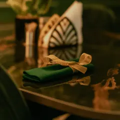 A close-up of the table setting, with a neatly folded napkin tied with a golden ribbon. I believe in paying attention to the small details.