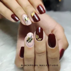 This design features a rich maroon polish with nude accent nails. I added hand-painted sticker-like art and gold foil to create a beautiful, artistic look on nails strengthened with Lexen gel.
