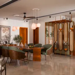 This dining space is all about creating a warm, inviting atmosphere. I combined rich wood finishes with soft green chairs and a beautiful cane partition to add texture and charm. The pendant lights and brass accents bring just the right touch of elegance for memorable dinners.