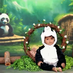 This little one is all dressed up in a panda costume, sitting sweetly in our bamboo forest set for a cute and cuddly portrait.