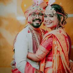 A classic portrait of a smiling Maharashtrian couple in their wedding attire. Their happiness and traditional outfits make for a timeless photograph.