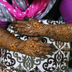 A candid shot of a bridal mehndi, showing the intricate details on the back of the hands.