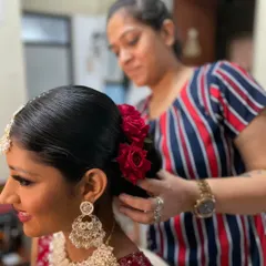 Carefully placing fresh red roses into this bride's sleek bun. I love using real flowers to add a personal and beautiful touch to my bridal hairstyles.