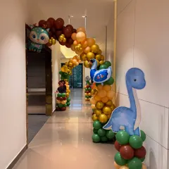 We create immersive entrances that set the tone for the party. This hallway was transformed into a jungle path with a long balloon arch and cute dinosaur and animal cutouts to welcome the little explorers.