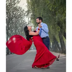 A classic Bollywood twirl! The vibrant red saree in motion against the lush green backdrop creates a beautiful, high-energy shot that’s full of life and romance.