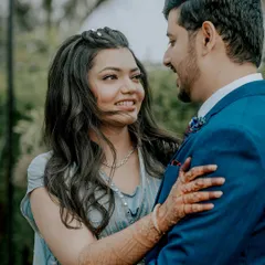 A close-up shot capturing the loving gaze between the couple. Her intricate mehendi is visible as she holds him, adding a traditional touch to this sweet, candid moment from their engagement photoshoot.