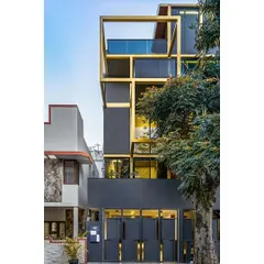 The exterior of the 'SOL' residence showcases our approach to urban architecture on a compact plot. A bold, interlocking golden frame creates a distinct facade, providing privacy while defining balconies and view corridors, proving that structural elements can also be the primary aesthetic feature.