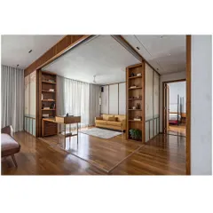 A view showing the sliding panels partially open, connecting the living room to a more private study. This demonstrates the home's ability to adapt its spatial configuration.
