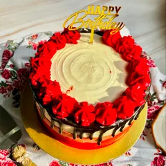 An overhead view of our Classic Chocolate Truffle Cake, showing the beautiful red piped roses and rich chocolate drip.