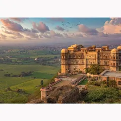 An expansive daytime view of the fort perched above the lush green valley. This image showcases the property's stunning location and architectural dominance in the landscape.