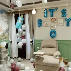 A beautiful room setup to welcome a new baby boy home. We use "IT'S A BOY" foil balloons, scattered floor balloons, and themed foil balloons like a baby bottle to create a warm and celebratory atmosphere.
