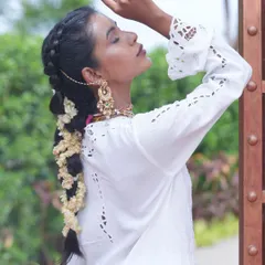 A stunning traditional bridal look featuring a long, thick braid adorned with flowers. Our extensions provide the necessary length and volume to create such intricate and beautiful hairstyles.