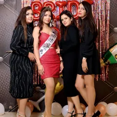 The bride-to-be poses with her friends in front of a festive balloon and streamer backdrop. This is a classic bridal shower photo that captures the core group.