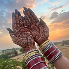 A perfect sunset shot showing off the gorgeous henna stain. The rich color of the mehndi against the warm light is just magical, especially with the bridal chura.