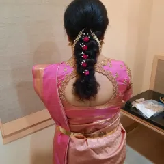 A beautiful, thick braid adorned with fresh pink and white flowers for a varapooja ceremony. This hairstyle is both traditional and incredibly pretty.