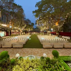 An enchanting outdoor evening setup, where strings of fairy lights hang like a canopy of stars over elegant guest seating, creating a truly magical and romantic atmosphere for your celebration.