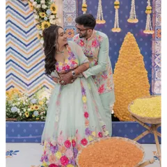 A happy couple shares a moment during their Moroccan-themed Haldi, surrounded by colorful decor and bowls of turmeric.