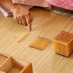 A single golden bead holds a universe of understanding. This is the heart of our philosophy: guiding the adult to see how simple, beautiful materials can open a child's mind to complex concepts like the decimal system. Learning with us is a process of joyful, hands-on discovery.
