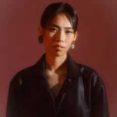 For this moody editorial portrait, I created a soft, diffused makeup look that works with the hazy, red-toned lighting. The focus is on a natural skin finish and subtly defined features to enhance the model's expression.
