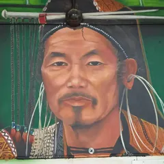 A close-up of a realistic portrait mural depicting a tribal man, highlighting the intricate details of his traditional attire and ornaments. This work is a tribute to the rich heritage and disappearing customs of indigenous communities.