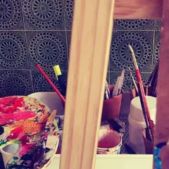 A peek at my art station with a colorful palette, brushes, and an easel. This is where the creative magic begins.