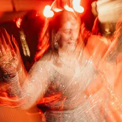 An artistic and abstract shot of a guest on the dance floor, with red light trails creating a sense of energy and movement.