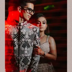 A powerful sangeet portrait using creative red light flares to add a touch of drama and passion to the couple's embrace.