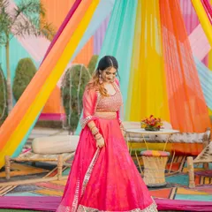 A full view of the pink lehenga, showing how I style it for a daytime wedding function. The colorful decor makes the outfit pop.