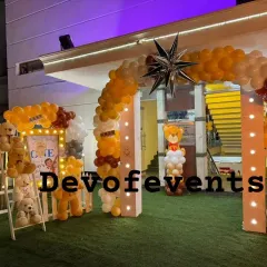 An outdoor entrance for a teddy bear party. I created a balloon arch with a star feature and set up a cute photo corner with a picket fence and a ladder full of teddy bears.