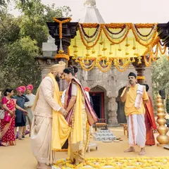 A Maharashtrian wedding ceremony held in front of a 300-year-old Ganesh temple. This image captures the 'antarpat' moment, just before the couple sees each other, highlighting the rich traditions and divine setting.