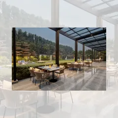 The outdoor dining terrace at the Courtyard by Marriott. The space is covered by a modern pergola with a glass roof, allowing for alfresco dining with views of the hotel's green lawns.