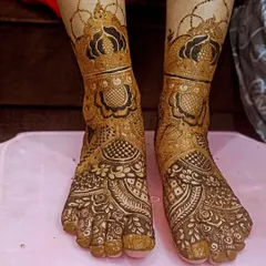 A beautiful and symmetrical foot design. The patterns on both feet mirror each other perfectly, featuring traditional motifs that extend from the toes to just above the ankle.